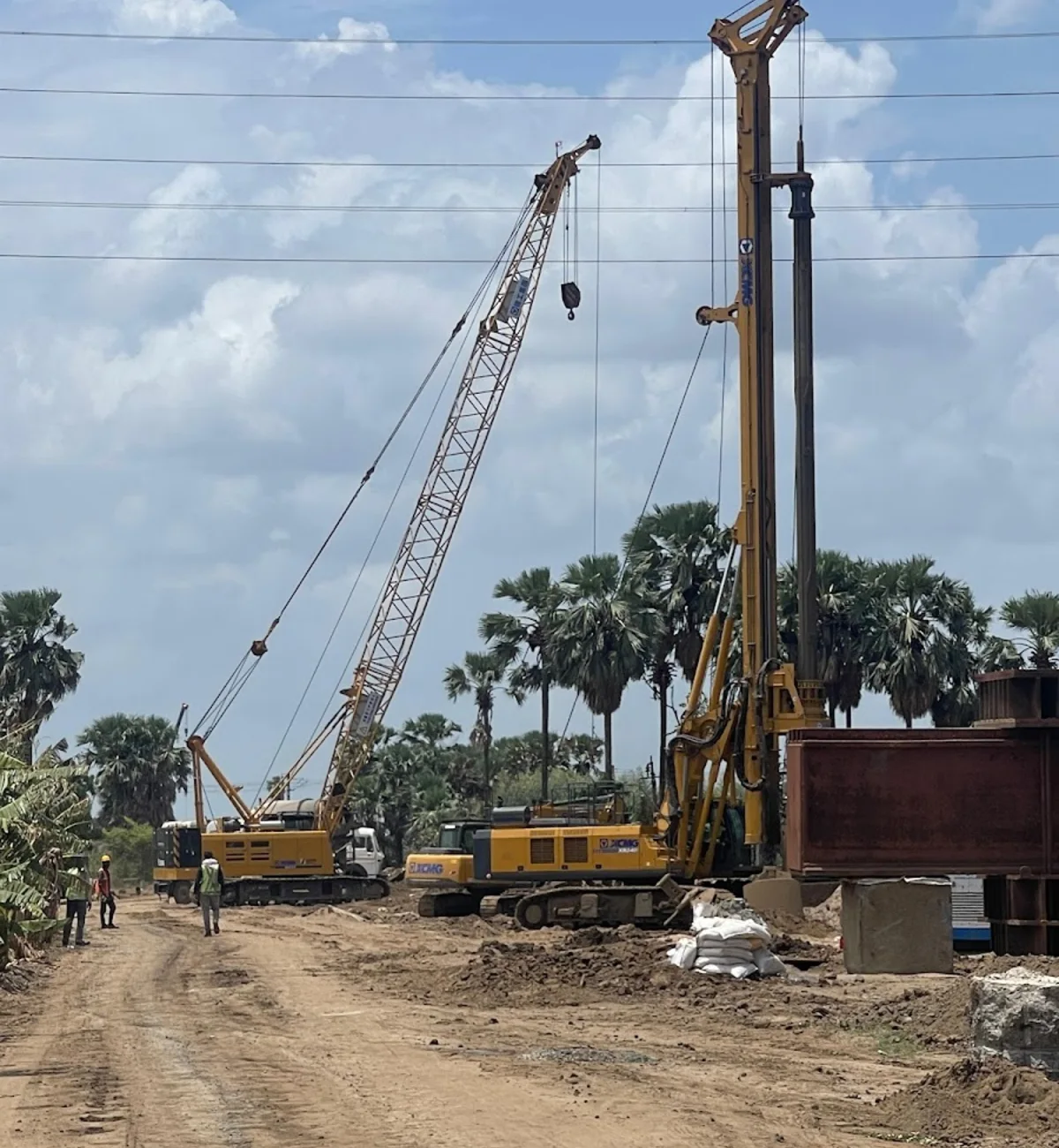 Crane and piling equipment working together at a construction site