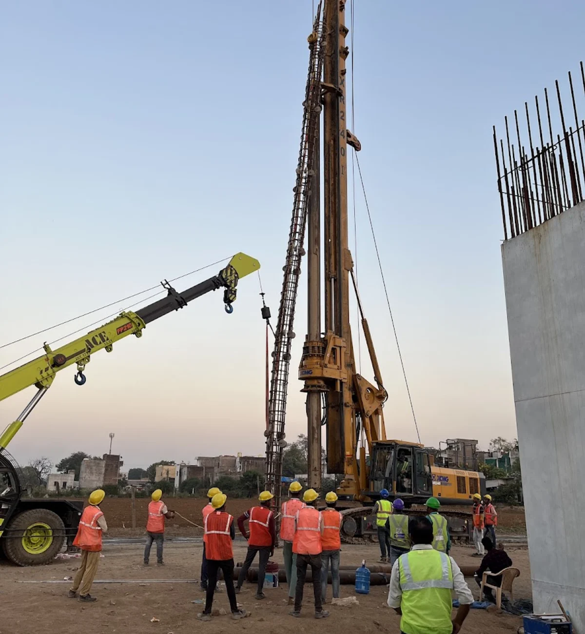 Foundation rig, crane support, and site team preparing pile work